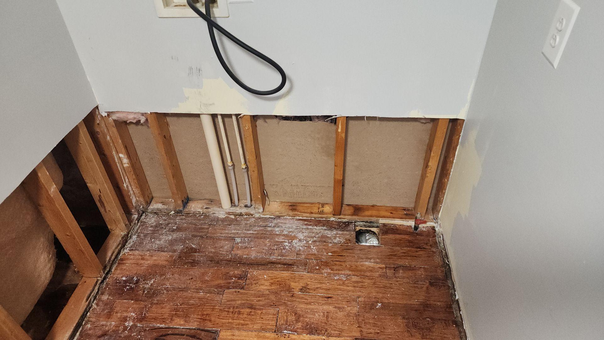 Removed damaged drywall behind washer and dryer